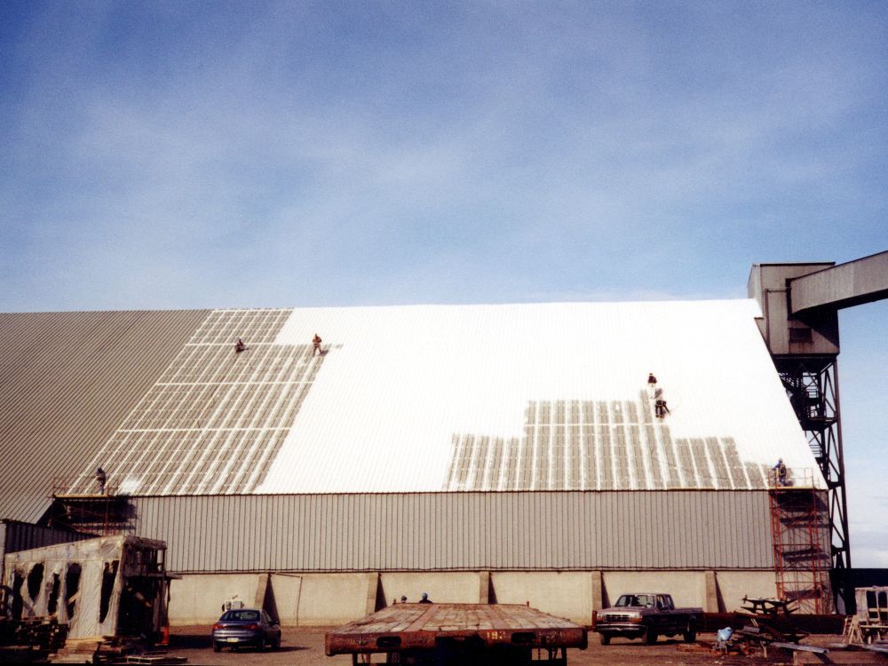 multiple men working on big building roof