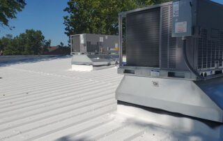Roof featuring white metal roof coating and two air conditioners