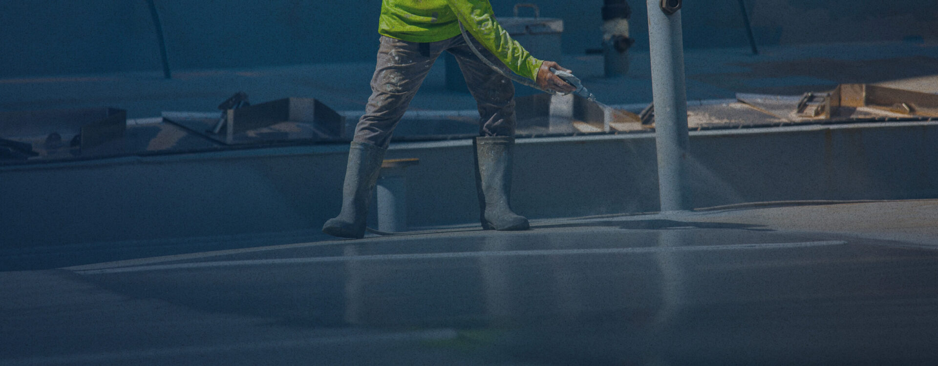 employee spraying roof with dark overlay