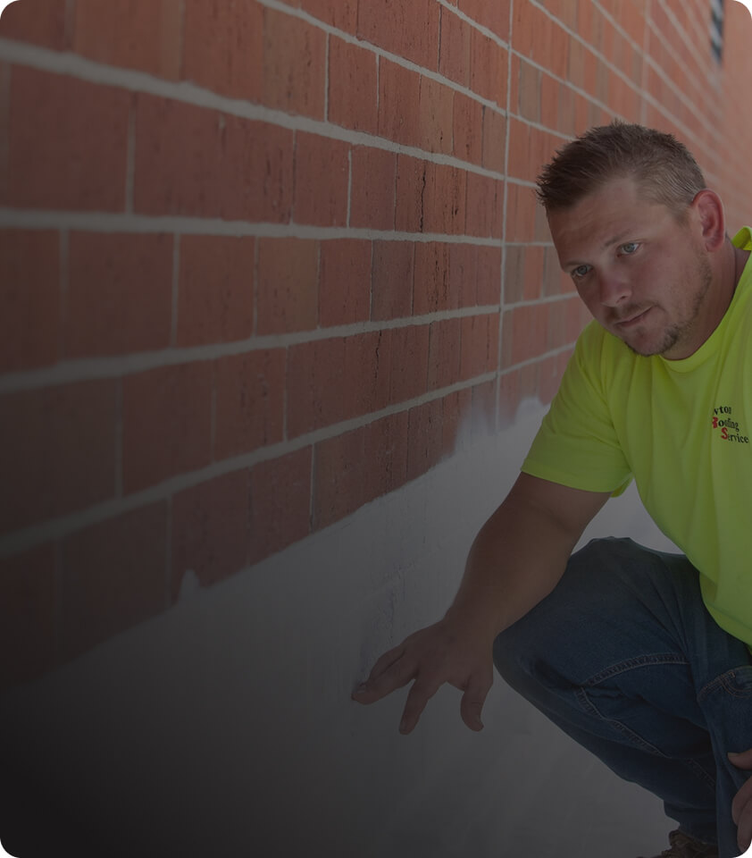 employee inspecting roof wall with dark overlay