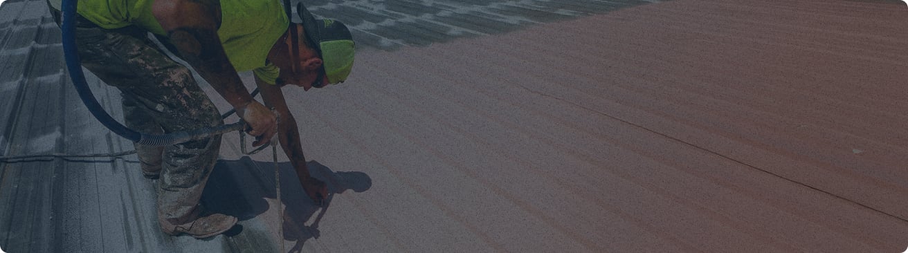 employee installing coating on roof with dark overlay